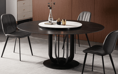 round dining table with a black pedestal base and leather chairs
