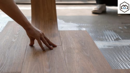 A worker installs Luxury Vinyl Plank (LVP) flooring onto a prepared subfloor